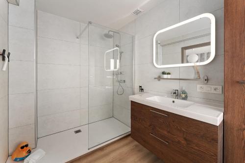 a bathroom with a shower and a sink and a mirror at Ruime woning 10p met zonnige tuin & nabij strand in Blankenberge