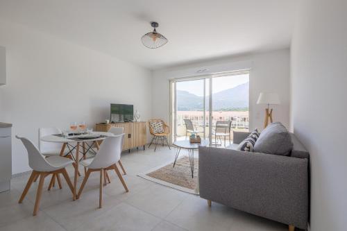 un salon avec un canapé et une table dans l'établissement Aranciu - Appt climatisé vue mer, à Lumio