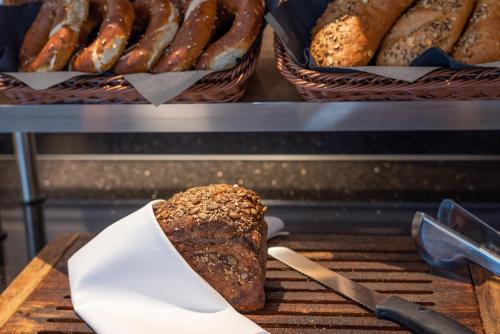 a loaf of bread on a grill with baskets of bread at Robenstein Hotel & SPA - Villa in Zwiesel