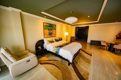 a bedroom with a bed and a chair in a room at BELAN HOTEL de NGOZI in Ngozi
