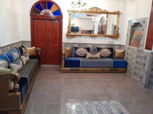 a living room with a couch and a mirror at Riad Ksar El Jadida Maroc in El Jadida