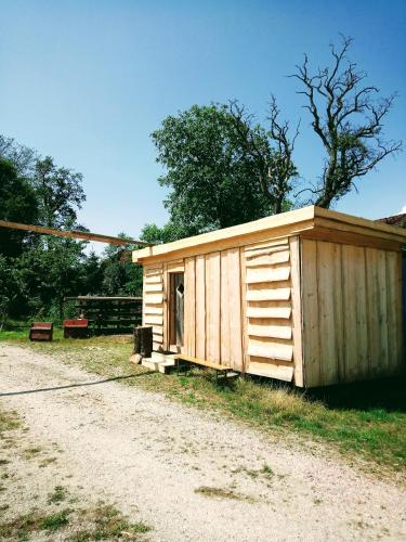 eine kleine Holzhütte an der Seite einer unbefestigten Straße in der Unterkunft Kleines Hüttchen. in Lenzing