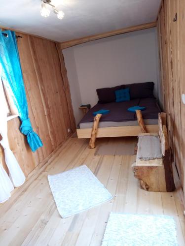 mały pokój z łóżkiem i drewnianą podłogą w obiekcie Kleines Hüttchen. w mieście Lenzing