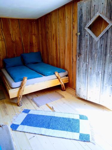 Cama pequeña en habitación de madera con alfombra en Kleines Hüttchen., en Lenzing