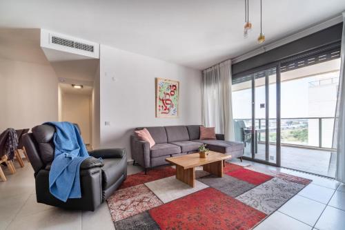 uma sala de estar com um sofá e uma mesa em Achziv Beach Haven 3BR Apartment by Sea N' Rent em Nahariya