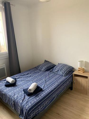 une chambre avec un lit avec deux serviettes dessus dans l'établissement Appartement proche des remparts - Avignon, à Avignon