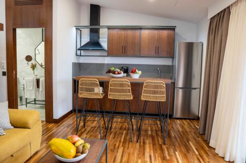 a kitchen with a bar with chairs and a refrigerator at Finca Pico in Los Realejos