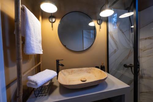 a bathroom with a stone sink and a mirror at Agapanthus Retreat in Kouvaláta