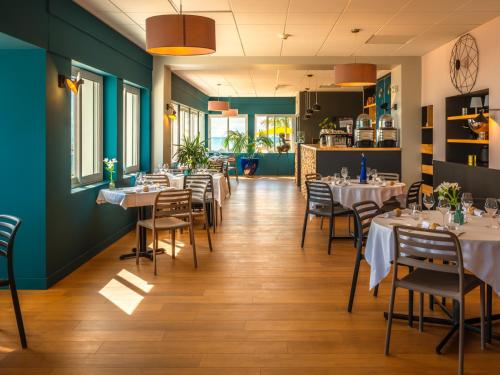 a dining room with white tables and chairs at La Villa Saint Jean in Les Sables-d'Olonne