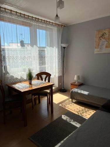 ウストカにあるPokoje u Kamyのテーブルとベッド、窓が備わる客室です。