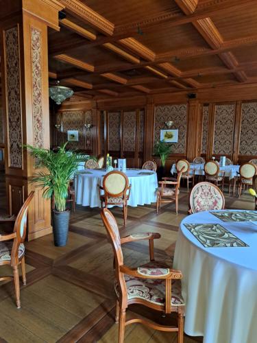 a dining room with white tables and chairs at Senator Gran Via in Będziemyśl