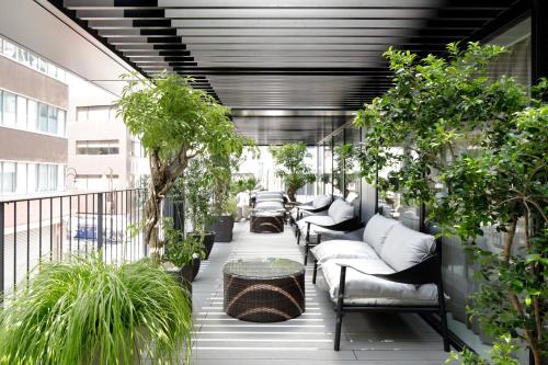 a balcony with couches and plants on a building at NOHGA HOTEL UENO TOKYO in Tokyo
