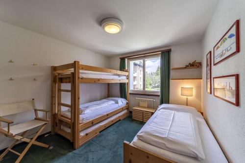 - une chambre avec 2 lits superposés et une fenêtre dans l'établissement Chesa Chatrigna - Celerina - apartment up to 5 people, à Celerina