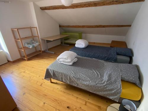 a small bedroom with two beds in a attic at Gîte de la tour de Paradis in Poligny