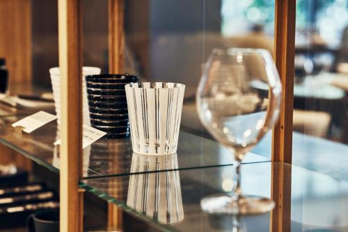 a glass table with a wine glass on it at NOHGA HOTEL UENO TOKYO in Tokyo