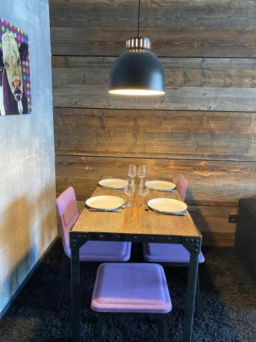 d'une table en bois avec des chaises et un éclairage tamisé. dans l'établissement IMMODREAMS - Le Flocon, à Avoriaz