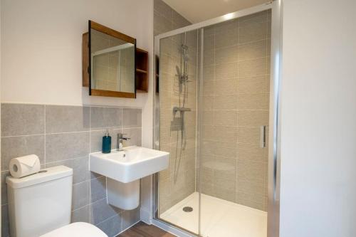 a bathroom with a shower and a toilet and a sink at Comfortable townhouse in Tetbury, parking & garden in Tetbury