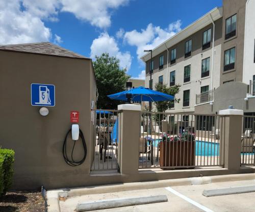 a fence with an umbrella and a table and chairs at Holiday Inn Express & Suites San Antonio NW near SeaWorld by IHG in San Antonio
