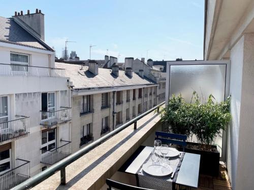 balcón con mesa y vistas a un edificio en Appartement A Deux Pas situé en Hyper Centre Ville en Ruan