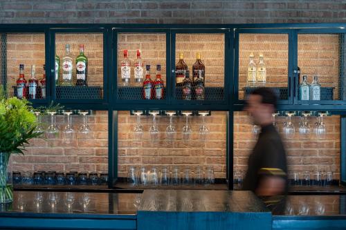a man walking past a bar with glasses on the wall at Parador de Ronda in Ronda