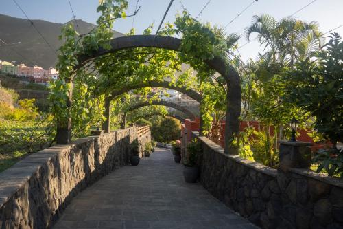 a stone walkway with an arch with potted plants at Finca Pico in Los Realejos