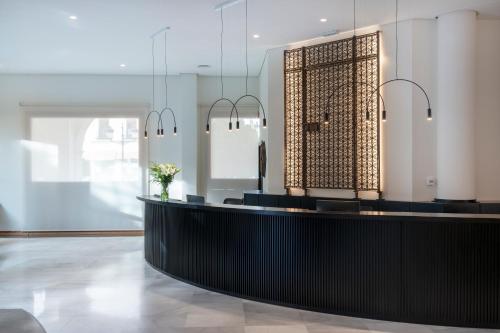 a lobby with a black counter and a window at Parador de Ronda in Ronda