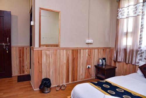 a bedroom with a bed and a mirror in a room at Rufina Lachung Deezong in Lachung