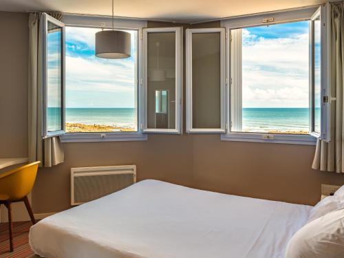 um quarto com uma cama e vista para o oceano em La Villa Saint Jean em Les Sables-dʼOlonne