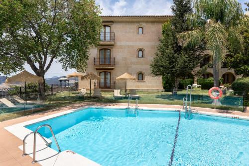 une grande piscine devant un immeuble dans l'établissement Parador de Ronda, à Ronda