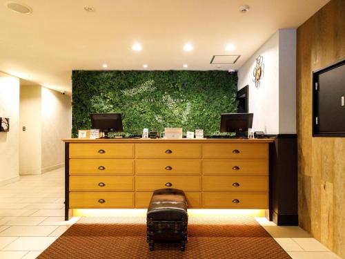 une chambre avec une commode avec un grand tableau au mur dans l'établissement Hotel La Foresta By Rigna, à Fukuoka