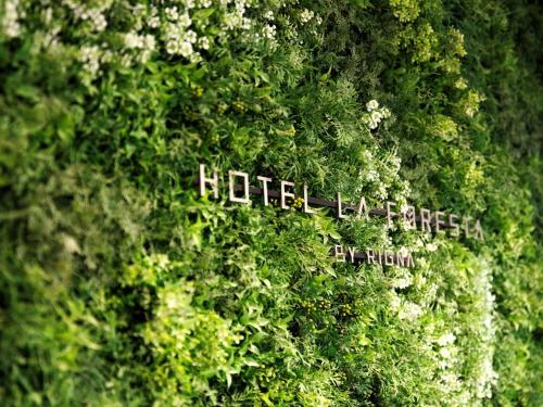 a bush with a sign in the middle of it at Hotel La Foresta By Rigna in Fukuoka