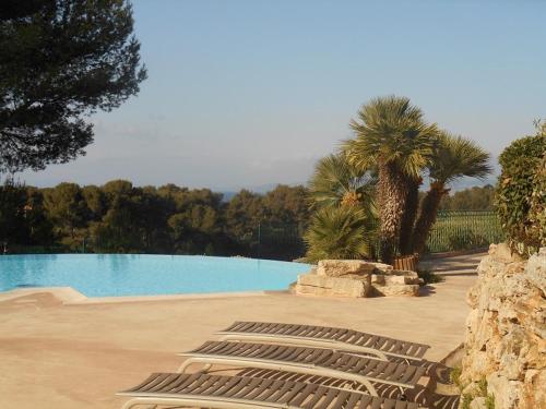 une rangée de chaises longues assises à côté d'une piscine dans l'établissement Fantastisk feriebolig med basseng og kort vei til havet, à Saint-Raphaël