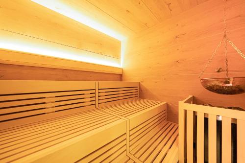 a small sauna with wooden walls and a chandelier at Robenstein Hotel & SPA - Villa in Zwiesel