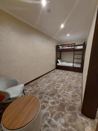 a living room with a table and a bunk bed at Mandarinnart HOTEL in Astara