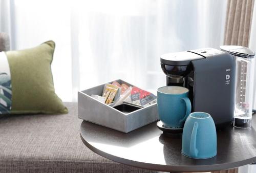 a coffee table with a coffee maker on a couch at Miyako City Osaka Hommachi in Osaka