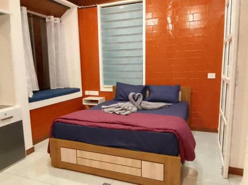 Un dormitorio con una cama con sábanas moradas y una ventana en Nostalgia Homestay, en Vythiri