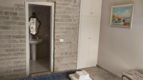 ein Badezimmer mit einem Waschbecken und einer Ziegelwand in der Unterkunft Agriturismo Tenuta Filippi in Narni