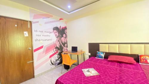 a bedroom with a pink bed and a desk at C Suites - Richfield in Bangalore
