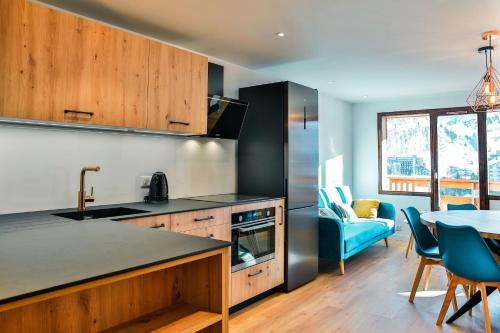 une cuisine et une salle à manger avec une table et des chaises dans l'établissement IMMODREAMS - Les Dents Blanches, à Avoriaz