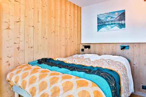 un lit dans une chambre avec un mur en bois dans l'établissement IMMODREAMS - Les Dents Blanches, à Avoriaz