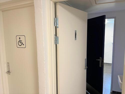 a door to a bathroom with a sign on the wall at Hirtshals Idrætscenter - Vandrehjem - Hostel in Hirtshals