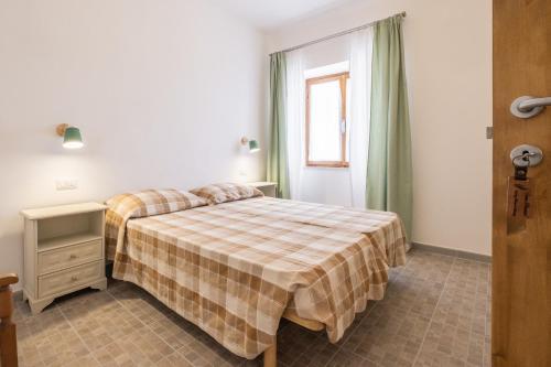 a bedroom with a bed with a plaid blanket at La sosta del pellegrino in Sorano