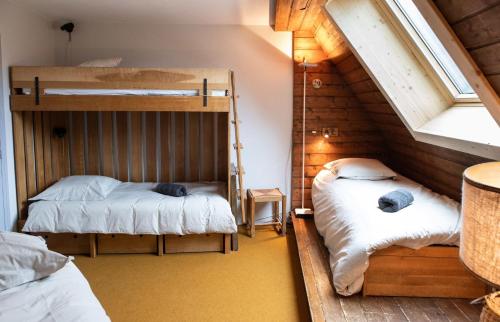 une chambre avec deux lits superposés et une fenêtre dans l'établissement IMMODREAMS - Le Mazot, à Morzine