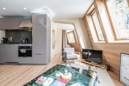 un salon avec une table et une cuisine dans l'établissement IMMODREAMS - Le Moutain Loft, à Morzine