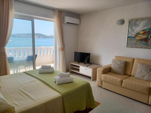 um quarto com uma cama, um sofá e uma janela em Apartments Amor em Trogir