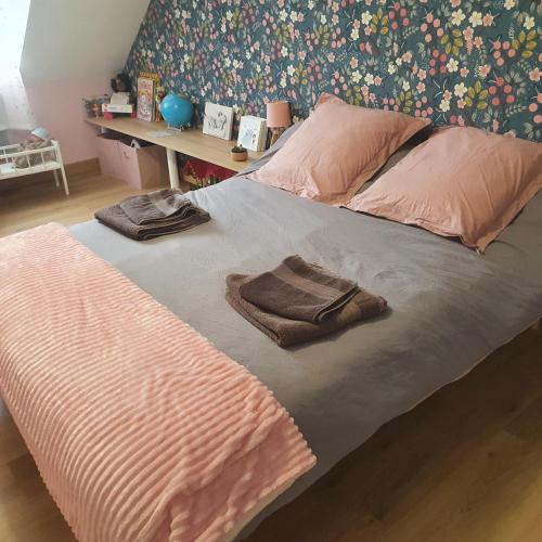 - un lit avec 2 serviettes assises au-dessus dans l'établissement Maison familliale à la campagne à 15 min du mans, à Roézé-sur-Sarthe