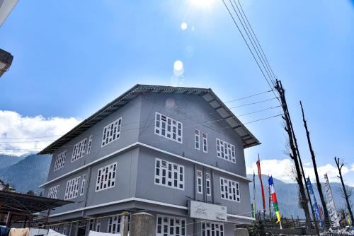 a large gray building with windows on top of it at Rufina Lachung Deezong in Lachung