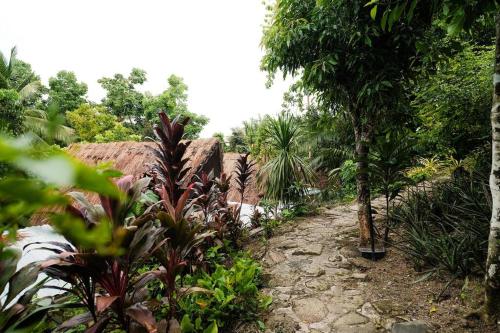 a path through a garden with trees and plants at Monte Alto Eco Resort Villas in Villaba
