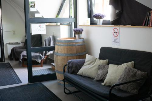 a living room with a couch and a barrel at Megacentrum Szállás in Szekszárd
