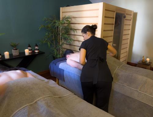 a woman standing next to a bed with a man at Ostella Spa & Resort in Bastia